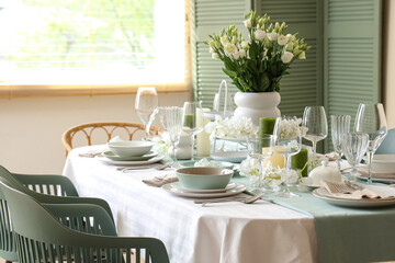 Beautiful table setting with white flowers for wedding celebration in room