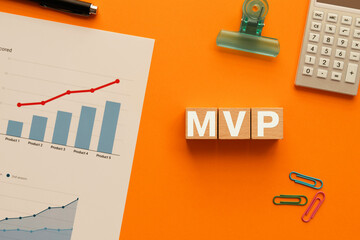 There is wood cube with the word MVP. It is an abbreviation for Minimum Viable Product as...