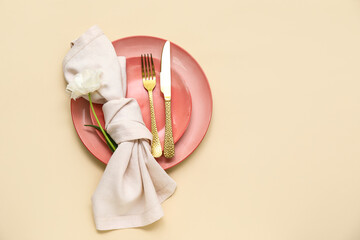 Stylish table setting with beautiful flower on beige background