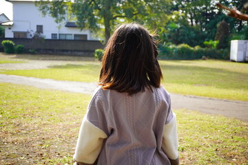 子供と過ごす休日。原っぱに遊びに来た。小学4年生の女の子の後ろ姿。