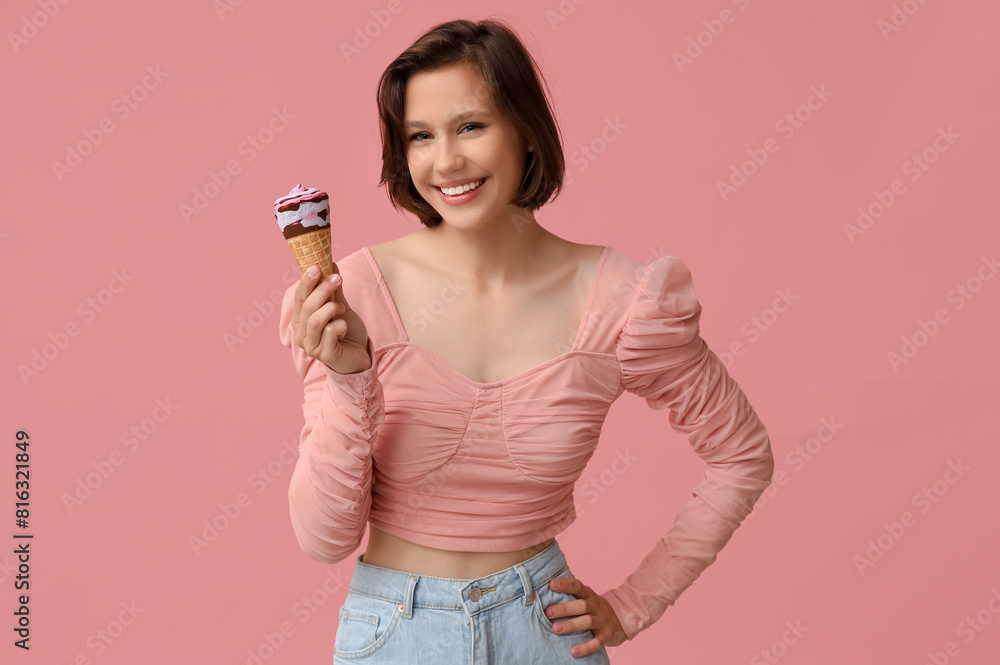 Canvas Prints Beautiful young woman with sweet ice-cream in waffle cone on pink background