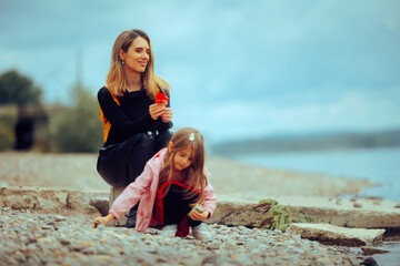 Traveling Mother and Daughter Admiring a Big River and Relaxing. People sitting in nature having a...