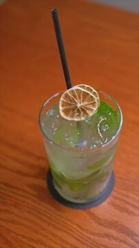 Vertical video of premium cocktails on wooden table. Slow motion cocktail videos. Concept of mixology and cocktails.
