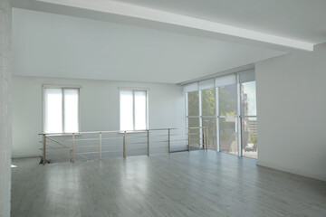 Large empty hall with windows and railings