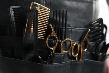Hairstylist with professional tools in waist pouch, closeup