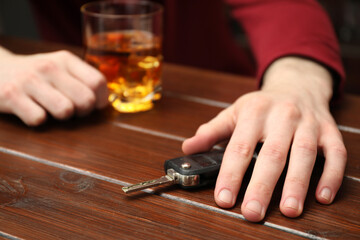 Drunk man reaching for car keys at table, closeup. Don't drink and drive concept