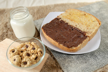 Bread with chocolate spread filling, milk and snack for breakfast