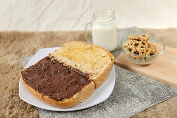Bread with chocolate spread filling, milk and snack for breakfast