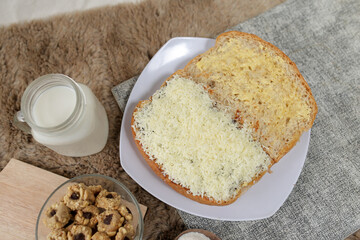 Bread with cheese, sweetened condensed milk, and butter. With white milk and snack on a table for breakfast	
