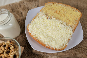 Bread with cheese, sweetened condensed milk, and butter. With white milk and snack on a table for breakfast	

