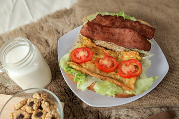 Big breakfast, bread, chicken slice, tomato, lettuce, smoked beef, egg, salad with milk. Bread sandwich fresh and healthy food meal lunch dinner breakfast slices of sandwiches.