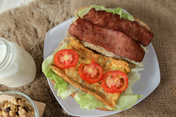 Big breakfast, bread, chicken slice, tomato, lettuce, smoked beef, egg, salad with milk. Bread sandwich fresh and healthy food meal lunch dinner breakfast slices of sandwiches.
