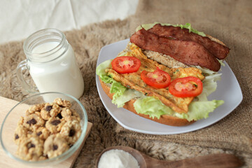 Big breakfast, bread, chicken slice, tomato, lettuce, smoked beef, egg, salad with milk. Bread sandwich fresh and healthy food meal lunch dinner breakfast slices of sandwiches.
