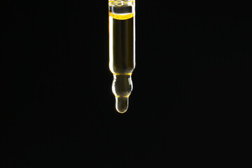 Pipette with tincture on black background, closeup