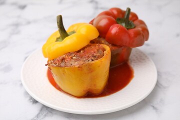Delicious stuffed bell peppers served on white marble table