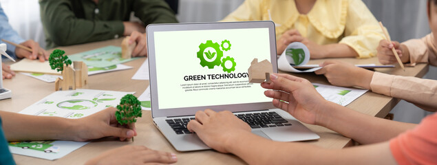 Green technology logo displayed on green business laptop while business team presenting green...