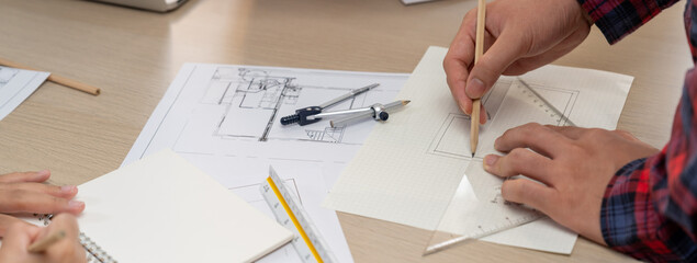 Professional architect hand drawing a blueprint by using ruler measuring length on table with...