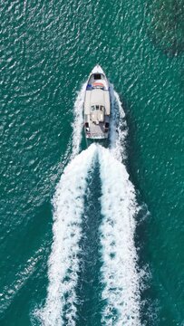 Vertical Screen: From A High Vantage Point, This Image Captures A Solitary Speedboat Racing Through The Deep Azure Waters Of Hawaii, Its Wake Marking The Ocean's Surface. 