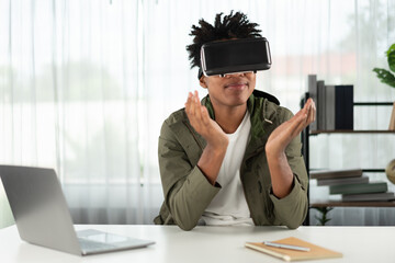 Surprised young African American looking through VR holding interesting data object hologram...