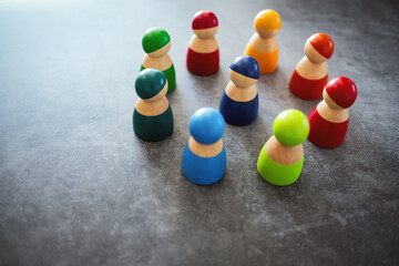 One of wooden figurine standing in the center of a circle among the others for the concepts of diversity, leadership and business