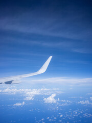 a wing of airplane and blue sky seen from the window of the seat