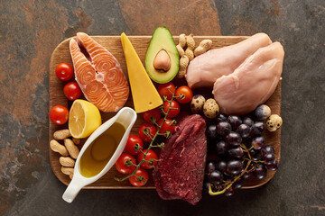 Raw Meat, Fish, Poultry, Cheese,fruits,vegetables With Olive Oil And Peanuts on Wooden Cutting Board