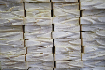 A stack of white soaps with blue ribbons in a basket