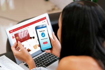 Young woman order or purchase product on internet using laptop and make transaction payment by...