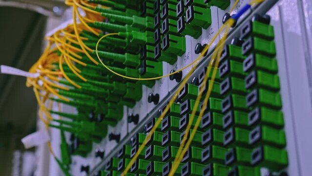 Close up of optical fiber switchboard hub in a server room. Stock footage. Concept of AI, internet, and modern technologies.