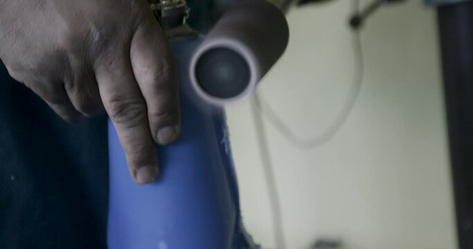 Sandpaper machine shaving plastic off prothetic leg - extreme close up