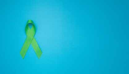 Top view of a green ribbon on a blue background.