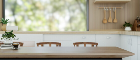 A wooden dining table with copy space for displaying products is in a contemporary kitchen.