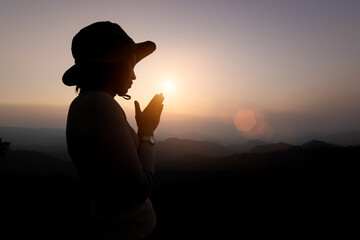 Person hands open palm up worship. Silhouette of prayer woman worship God in the morning with...