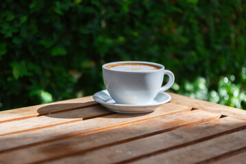 Hot latte art coffee cup on wooden table