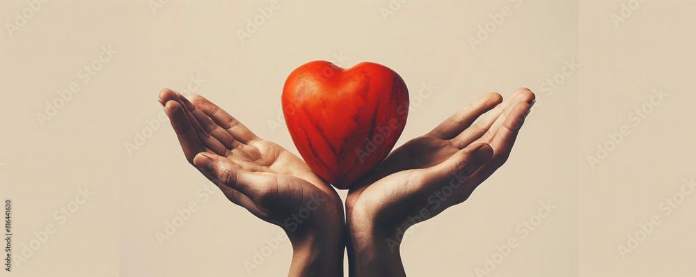 Poster against a minimalist, solid-colored background, two hands present a bright red heart, creating a str