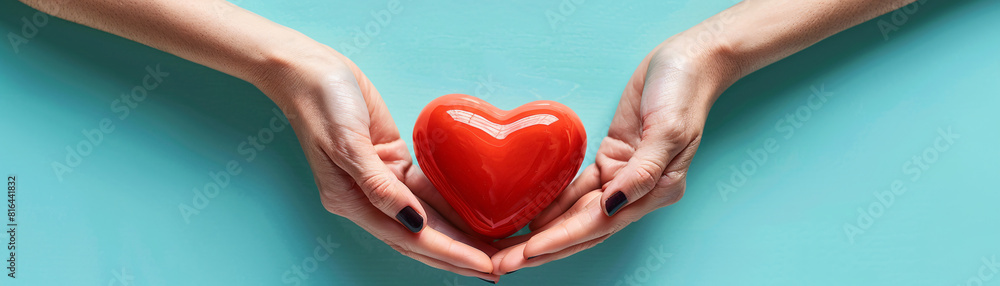 Poster two hands gently hold a bright red heart against a minimalist color background, creating a striking 