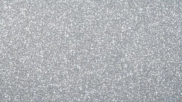 十字の光芒を作りながら輝く銀のグリッターのループ背景