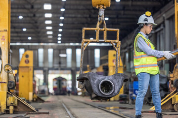 Maintenance engineer uses machine to lift and replace locomotive parts, reducing carbon emissions.
