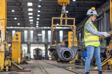 Maintenance engineer uses machine to lift and replace locomotive parts, reducing carbon emissions.