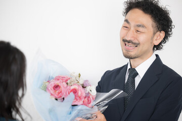 プレゼントの花束を渡す、受け取る男性のイメージ　いつもありがとう