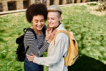 Two young women tenderly hugging in a lush green park under the warm sunlight.