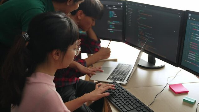 Slow motion back end software developer engineer for computer programming working together on debugging writing computing code, solving complex algorithms display on monitor in office. Burgeoning