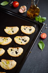 sliced baguette pieces on a baking tray making croutons