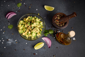 Chopped ingredients in a glass bowl - avocado, pepper and cooking olive oil