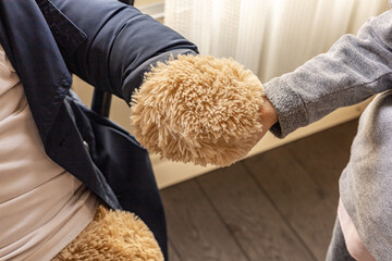 Kid Holding Hands With a big plush toy close up. Friendship, understanding, acquaintance,  personal...