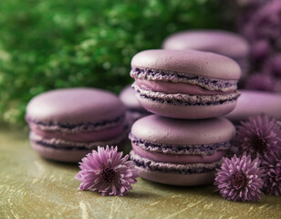 Sweet purple macarons or macaroons and lilac Aster flowers on wooden table