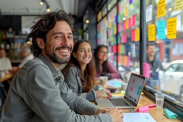 A diverse team of young professionals engaged in a brainstorming session at a cafe. They are surrounded by colorful sticky notes on the window, sharing ideas and working collaboratively on laptops.
