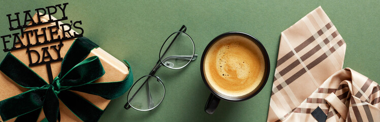 Father’s Day celebration concept with a warm cup of coffee, stylish eyeglasses, necktie, and...