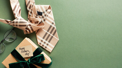 Fathers Day Concept. Flat lay gift box, necktie, and eyeglasses on a green background. Ideal for...