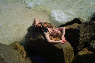 Tanned sexy slim bikini model on beach vacation. Girl in swimsuit bikini at sea. Sexy body of sensual woman in bikini. Summer vacation on tropical beach. Summer lingerie swimwear bikini.